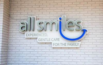 All Smiles Dental logo hanging outside the office
