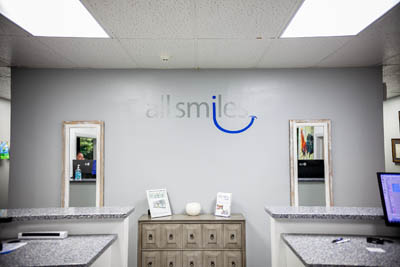 All Smiles Dental logo on the wall of the front office